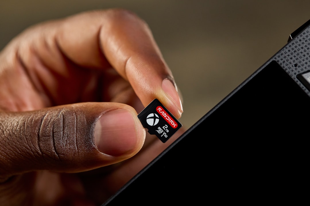Hand inserting an xbox microsd card into a device.
